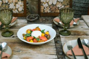 a white bowl filled with lots of vegetables on top of a wooden table