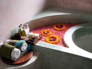 A serene wellness space with a bath tub and floral arrangements