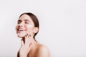 A woman smiles while she holds her hand to her face