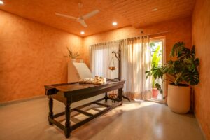 A massage table in a spa room with orange walls.