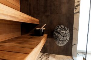 Wooden sauna interior with stones and bucket