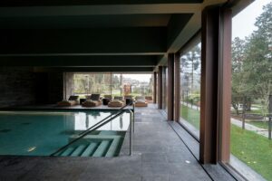 Indoor swimming pool with lounge chairs and large windows