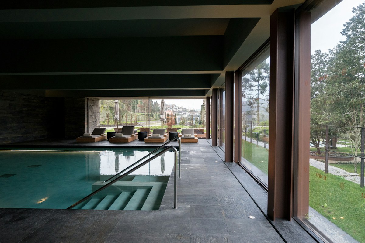 Indoor swimming pool with lounge chairs and large windows