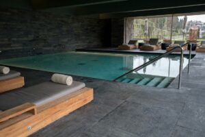Indoor swimming pool with lounge chairs and large window