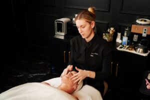 Esthetician performs a facial on a client