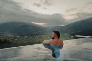 A man in an infinity pool overlooking a valley in Sorafurcia, Italy